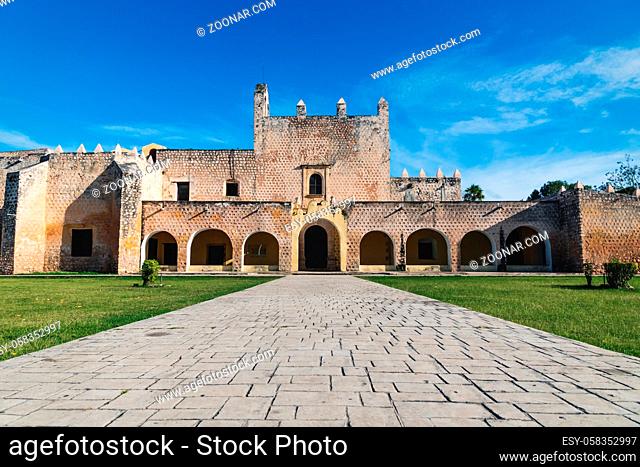 Stone path Path to the facade of the Convent de San Bernardino de Siena with grass field in Valladolid, Yucatan, Mexico