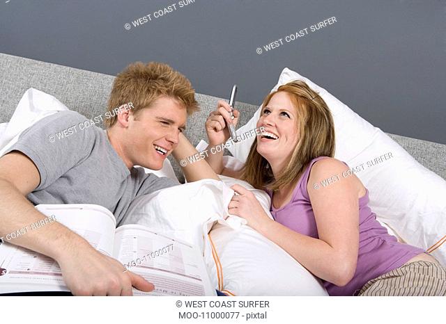 Couple Using Cell Phone Together Bedroom