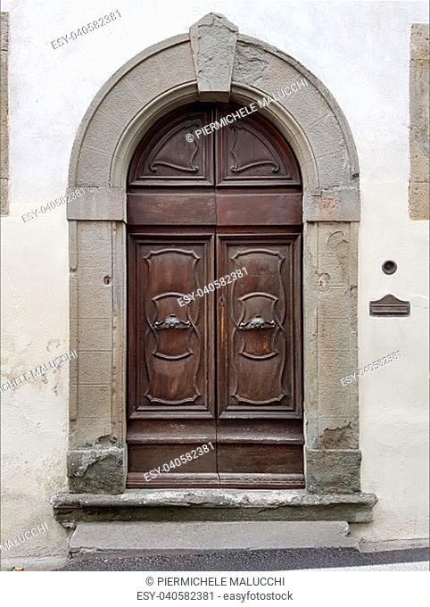 worn old door with antique handles in burnished metal and curved decorations
