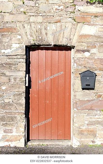 brown wooden doorway and a post box