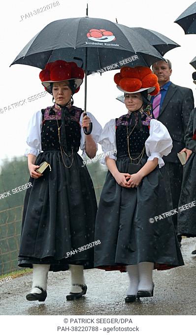 Candidates for confirmation Maria Hansmann (L) and Louisa Hildbrand (R) wear traditional clothing as they walk on their way to church in Kirnbach, Germany