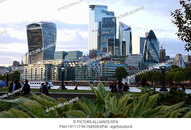 05 September 2019, Great Britain, London: In the evening view over the Thames to the skyscrapers in London's financial district