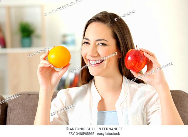 Girl showing apple and orange fruits