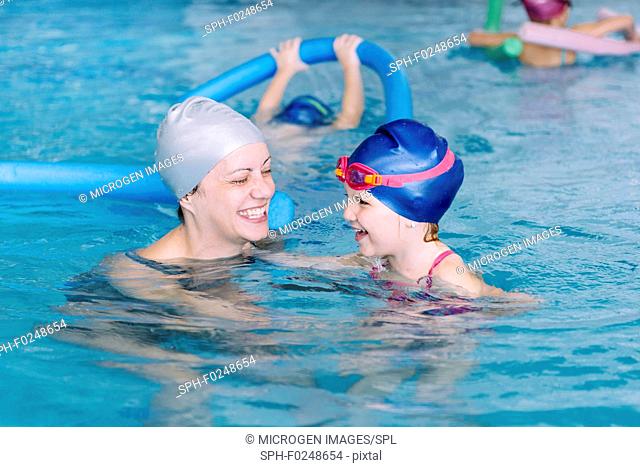 Swimming lesson for children. Swimming instructor with happy little child