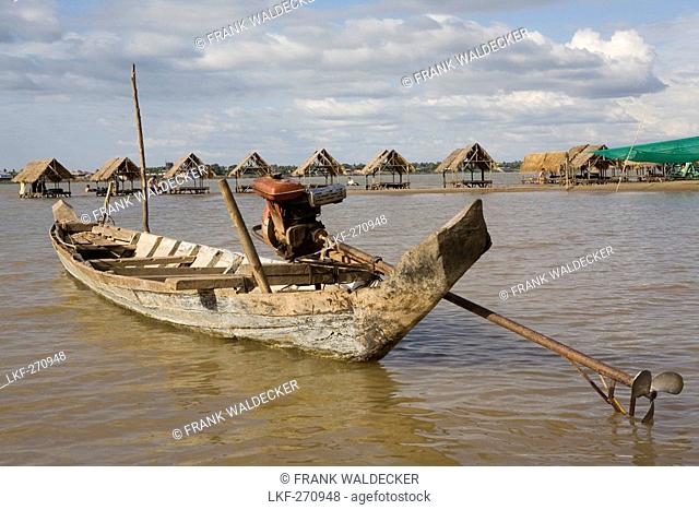 Fishing boat and beach with huts on the island Koh Deik in the Mekong River, Cambodia, Asia