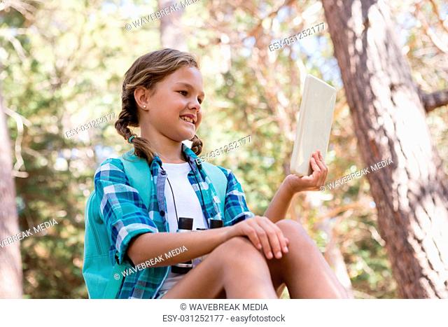 Girl looking at digital tablet in the forest