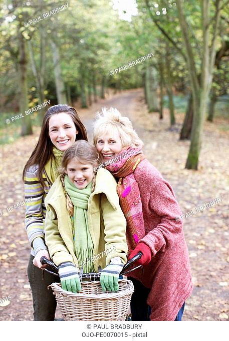 Grandmother, mother and daughter riding bicycles in park