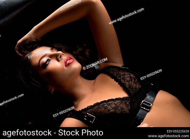 Brunette in black lace bra lying on the sofa high angle shot