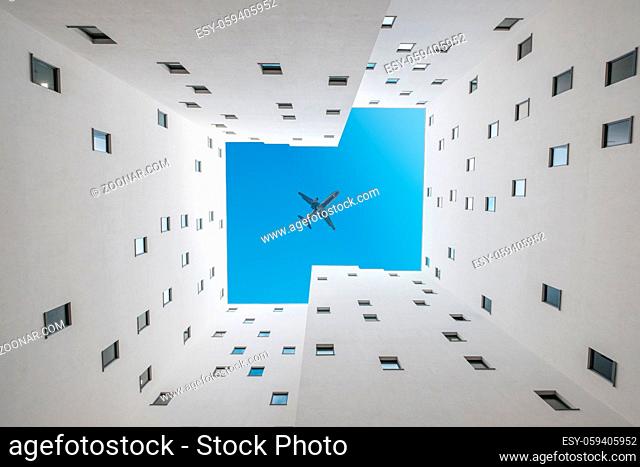 looking up inside apartment building courtyard - building facade, court and blue sky -
