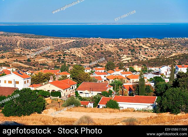 The view of cosy residential houses of Pissouri village on the side of a green hill. Limassol district. Cyprus