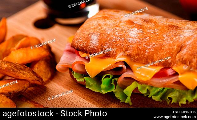 Sandwich with potato wedges fried close-up on restaurant table
