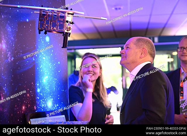 01 September 2023, North Rhine-Westphalia, Cologne: German Chancellor Olaf Scholz (SPD) looks at a model of the MASCOT lander (Mobile Asteroid Surface Scout)...