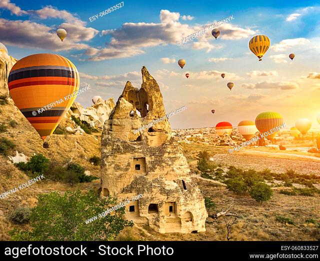 Ballooning over conical caves in Cappadocia at sunrise