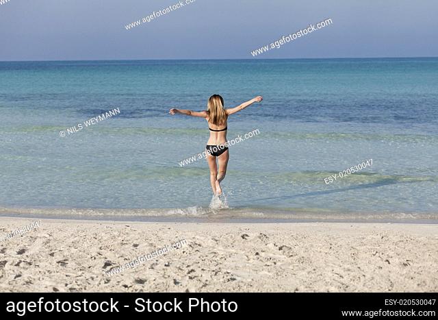 Frau mit Bikini im meer beim Springen Querformat