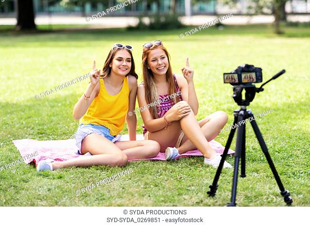 teenage bloggers recording video by camera in park