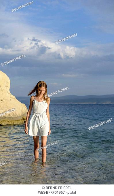 Croatia, Lokva Rogoznica, girl wading in water near seashore
