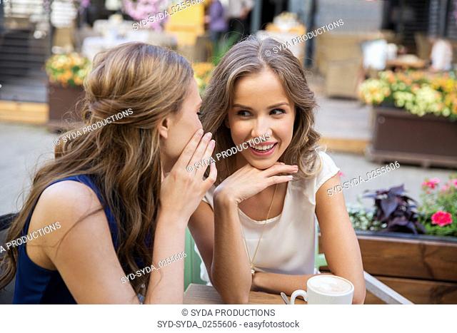 happy young women drinking coffee at outdoor cafe