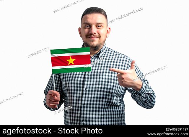 White guy holding a flag of Suriname and points the finger of the other hand at the flag isolated on a white background