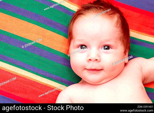 portrait of a smiling baby in a striped fabric
