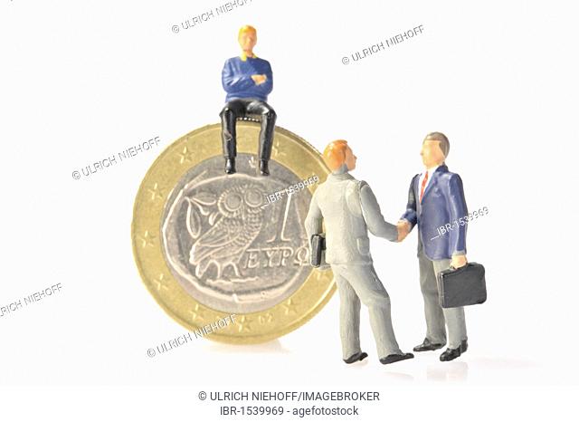 Figures and a Greek Euro coin, symbolic image for the financial crisis in Greece