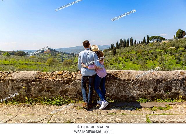 Young couple embracing at wall in Florence, Tuscany, Italy