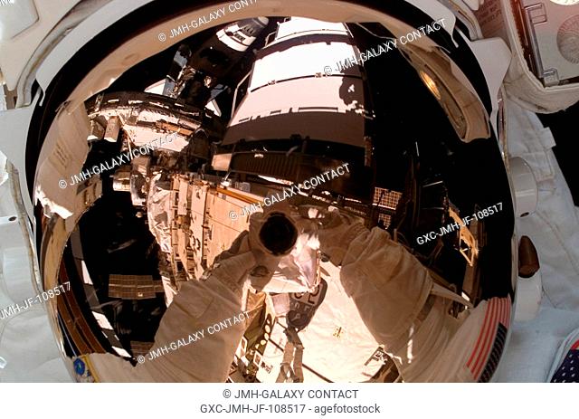 Astronaut Rick Mastracchio, STS-118 mission specialist, uses a digital camera to expose a photo of his helmet visor during the mission's first planned session...