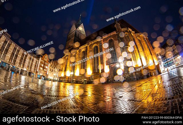 dpatop - 23 December 2020, Lower Saxony, Hanover: A star is projected onto the tower of the Marktkirche while raindrops bead on the objective lens (shot with...