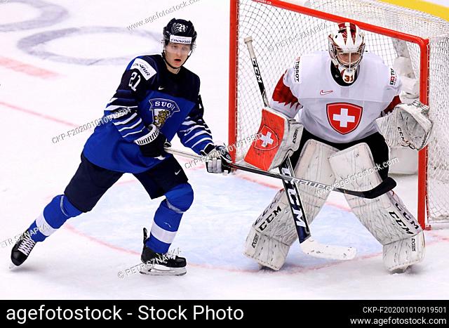 L-R Patrik Puistola (FIN) and goalkeeper Stephane Charlin (SUI) in action during the 2020 IIHF World Junior Ice Hockey Championships Group A match between...