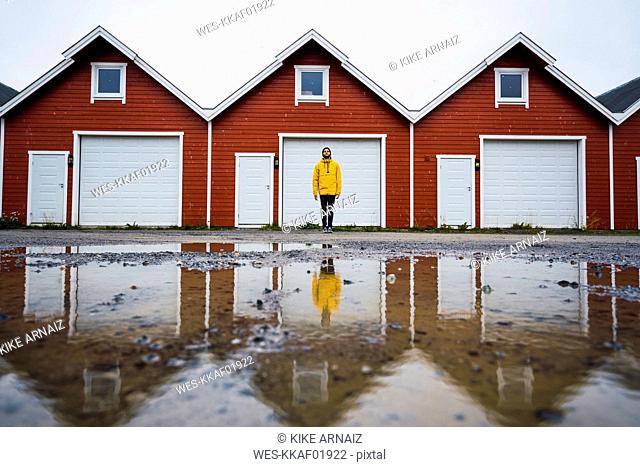 Norway, man standing in front of row of huts