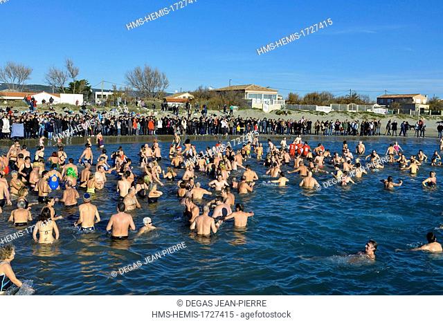 France, Herault, Frontignan, swimmers at sea during the bath of the new year with a background crowd on a beach