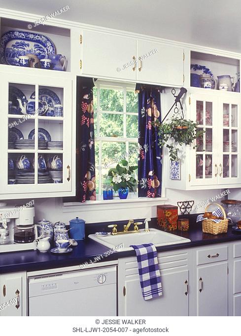 KITCHENS - White cabinets, blue laminate counter top, Sink area, window, with blue curtains, Blue Willow pattern china in cupboards, display shelves