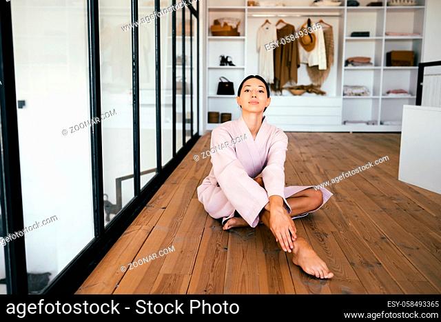 Portrait of a beautiful healthy woman in bathrobe posing at camera indoors