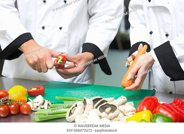 Close up of two chefs preparing vegetables
