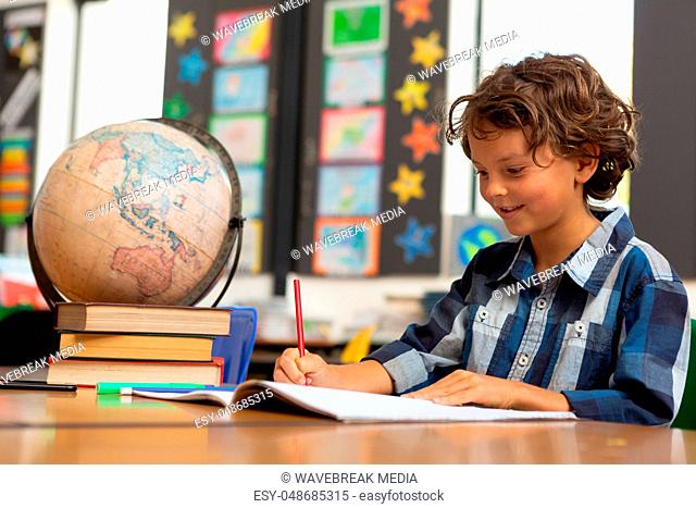 Schoolboy studying at desk in the classroom