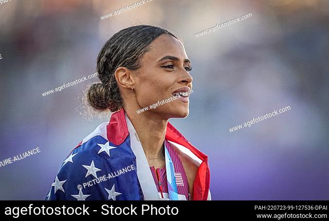 22 July 2022, US, Eugene: Athletics: World Championships, 400m hurdles, final: Sydney Mclaughlin from the USA stands wrapped in US flag and with her gold medal...