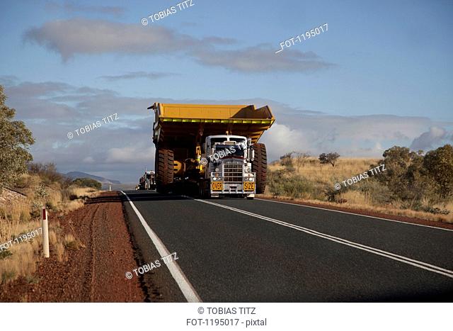 A truck with a wide load driving on a desert highway