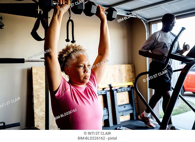 Black couple lifting working out in garage