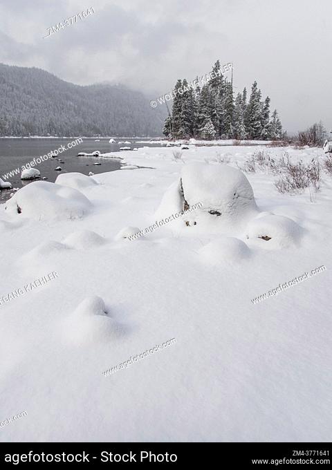 View of the shoreline with the snow-covered Emerald Island in the background at Lake Wenatchee State Park in eastern Washington State, USA