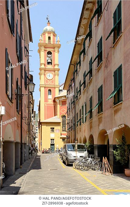 foreshortening of narrow street with the belltower of San Giacomo di Rupinaro church in background, shot at Mediterranean little town of Chiavari, Genova