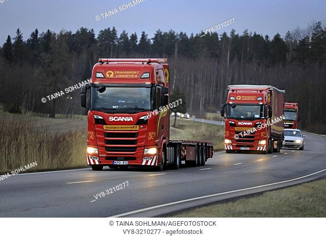 Salo, Finland - December 14, 2018: Fleet of red Next Generation Scania S500 semi trailer trucks of Translog on the road in Finland on cloudy evening