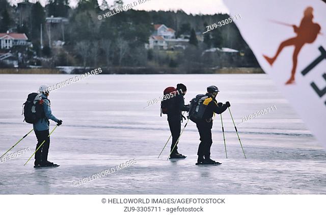 Long distance ice skaters with ice poles on Lake Malaren with blurred logo of ice skater, Sigtuna, Sweden, Scandinavia