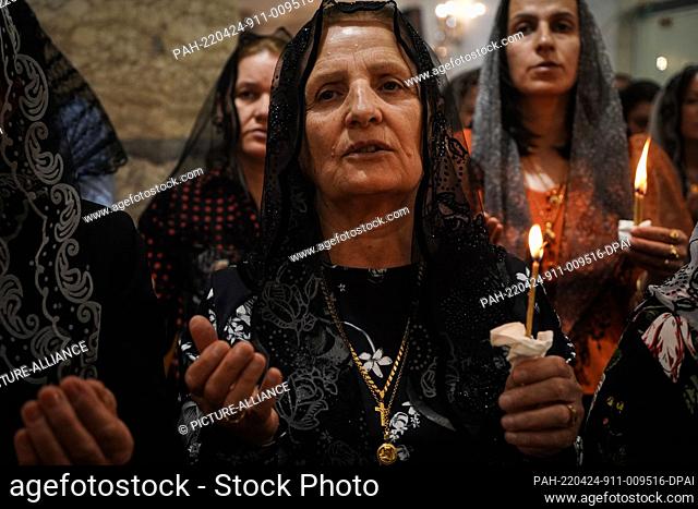 24 April 2022, Iraq, Bartella: Believers hold candles lit from a flame of the Holy Fire brought from the burial place of Jesus in Jerusalem