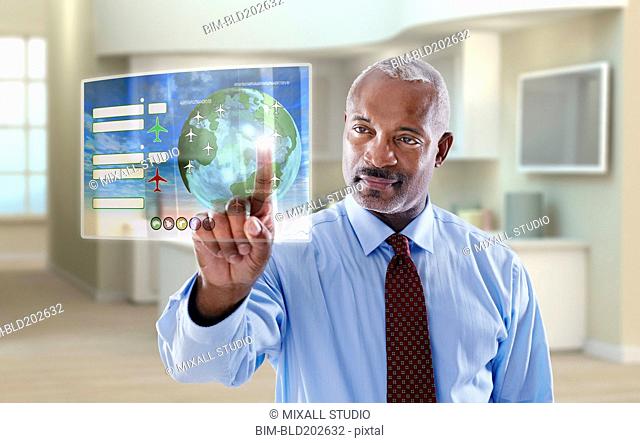 Black businessman using digital display in office