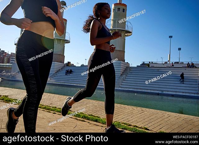 Two sportswomen jogging at a lake in the city, Barcelona, Spain