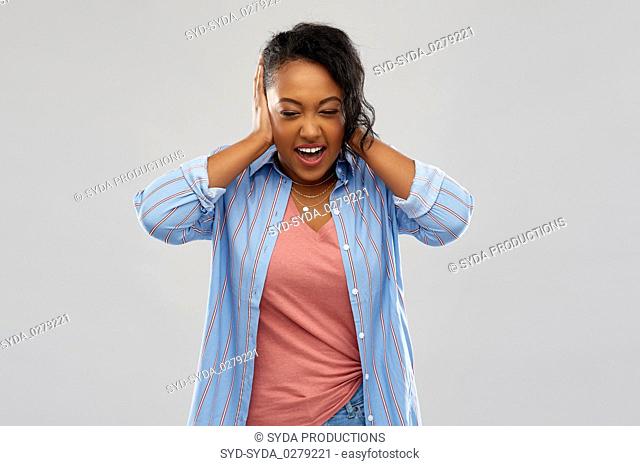 african american woman closing ears by hands