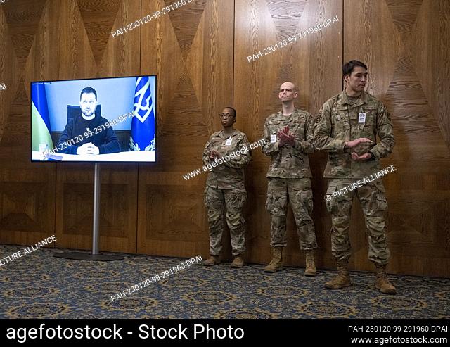 20 January 2023, Rhineland-Palatinate, Ramstein: U.S. Air Force soldiers applaud as Ukrainian President Selenskyj, who is being videotaped, delivers his speech