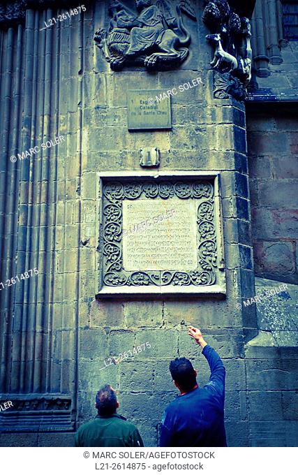 A man pointing a medieval inscription on a wall of Barcelona Cathedral. Barcelona, Catalonia, Spain