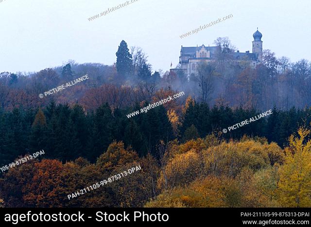 05 November 2021, Bavaria, Coburg: Morning mist rises between the autumnally coloured trees near the Veste Coburg. A ceremony is held in Coburg to mark 100...