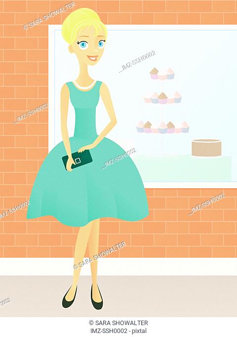 A woman in a retro dress standing in front of a cupcake bakery