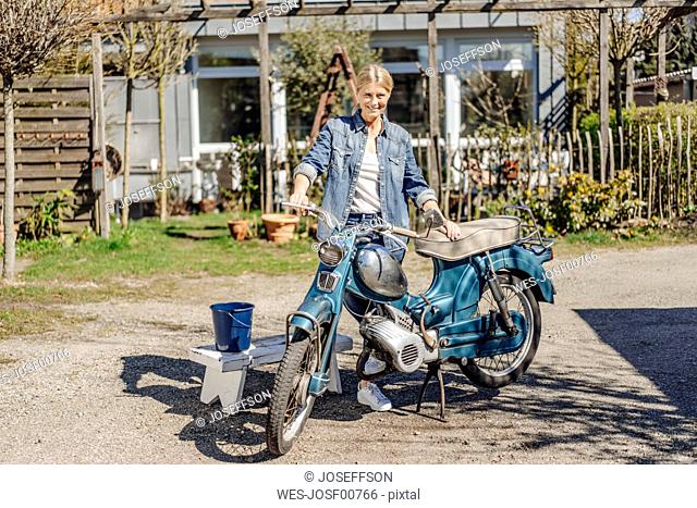 Smiling woman with vintage motorcycle